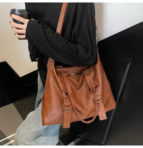 Sac fourre-tout en cuir marron avec anneaux argentés et une longue bandoulière réglable