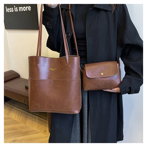 Detail of vintage brown tote bag set with textured leather and gold magnetic buckle