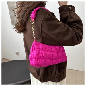 Close-up of rose red quilted cloud bag with gold chain strap and padded fabric handle