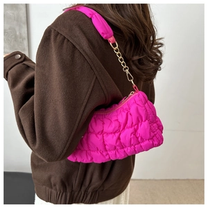 Detailed back view of a puffy quilted cloud bag in vibrant magenta with a gold chain strap