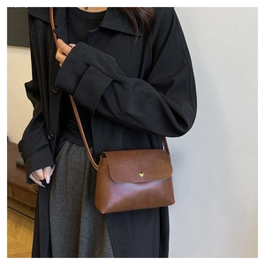 Nahaufnahme einer braunen Vintage-Tote-Bag aus PU-Leder mit goldener Schnalle an Model