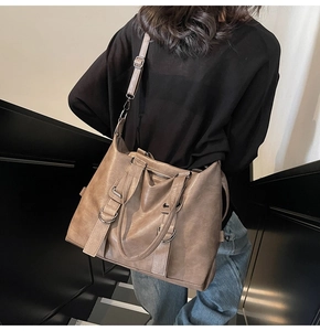 Détails du sac cabas marron vintage montrant la texture du cuir et les boucles argent