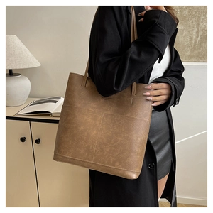 Dettaglio borsa tote in pelle marrone con logo SENGDAISHU e cuciture rifinite
