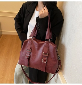 Détail d'un grand sac cabas vintage bordeaux à texture grainée porté par un mannequin