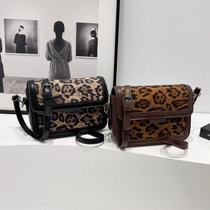 Retro leopard print crossbody bags in black and brown finishes displayed on a white stand