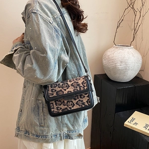 Vintage leopard print crossbody bag with black leather trim worn with denim jacket