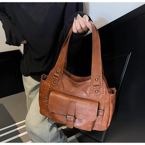Detail of vintage brown PU leather tote bag with side buckles and large capacity pocket