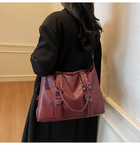 Détail du sac cabas bordeaux vintage avec texture cuir et boucle métallique argentée