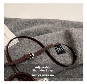 Détail de la bandoulière réglable en cuir ciré marron foncé avec boucle en métal argenté