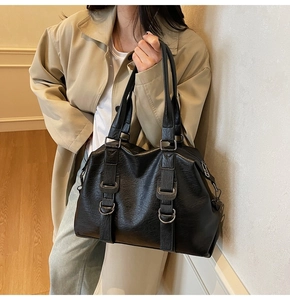 Grand sac cabas noir vintage avec boucles en métal argenté porté par un mannequin
