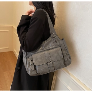 Detail of grey large capacity tote bag featuring retro lychee texture and buckle pockets