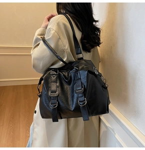 Détail d'un sac cabas en cuir noir avec boucles métalliques et sangles de style industriel