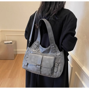 Detailed view of vintage gray tote bag with flap pocket and decorative buckle accents