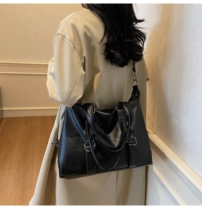 Vue latérale d'un grand sac cabas noir sur un mannequin portant un trench-coat beige