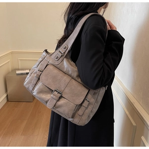 Detailed view of taupe retro faux leather tote bag with buckle pocket and metal hardware