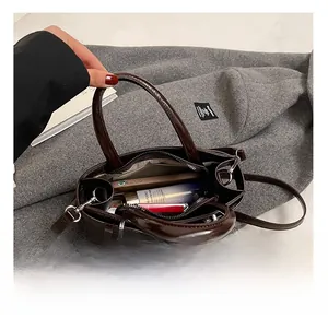 Détail de l'intérieur du sac en cuir verni marron avec compartiments et cosmétiques