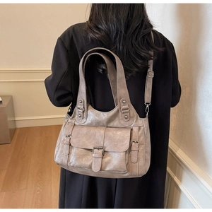Detail of vintage taupe shoulder bag showing soft washed PU leather texture on a coat