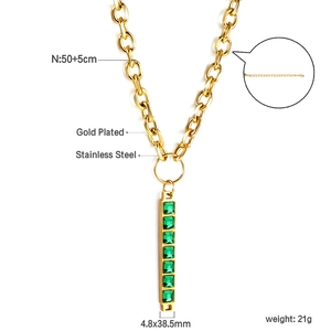 Dettaglio di collana in acciaio inossidabile dorato con sette gemme verdi verticali