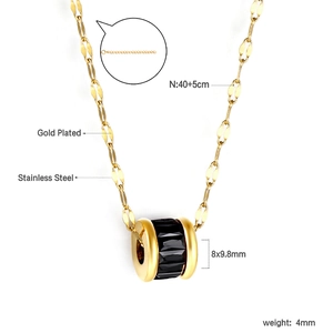Dettaglio della collana vintage in acciaio placcato oro con pietra nera e catena di estensione