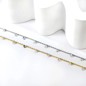 Détail de chaînes de cheville dorées et argentées avec pierres de zircone cubique rondes