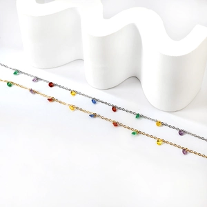 Détails de bracelets de cheville en or et argent avec cristaux géométriques colorés sur blanc