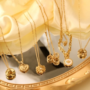 Collection de colliers en acier doré avec perles et pendentifs cœur sur tissu de soie