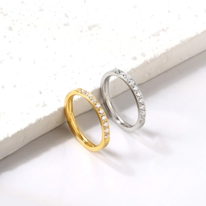 Set of gold and silver minimalist stainless steel rings with zircon stones on stone background