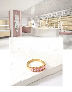 Close-up of a gold ring with five pink oval gemstones set on a white stone base