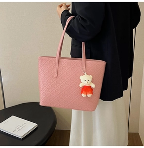 Pink leather tote bag detail with daisy letter embossing and white bear charm