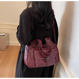 Burgundy faux leather tote bag with pebble texture and silver buckle shown on model
