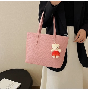 Detailed view of pink tote bag with Daisy Louis letter embossing and cute bear charm