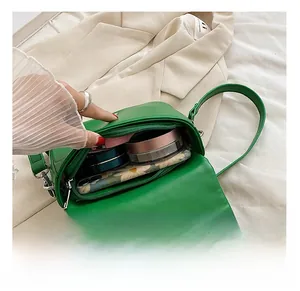 Macro view showing internal capacity of green leather crossbody bag with zipper closure