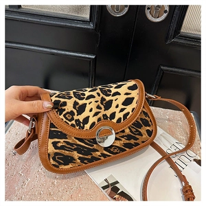 Detailed close-up of leopard print shoulder bag with brown leather trim and silver clasp