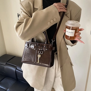 Sac à main vintage marron foncé avec boucle de ceinture et pendentif clé