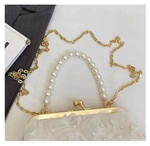 Détail du sac à fleurs en dentelle blanche avec anse perle et chaîne dorée sur costume