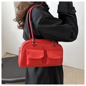 Close-up of bright red crocodile pattern leather bag with dual front flap pockets