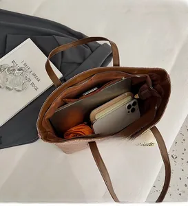 Interior view of large brown tote bag showing spacious capacity for laptop and daily items