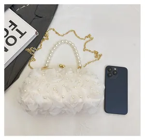 Détail du sac de soirée en dentelle blanche avec roses en satin 3D et perles