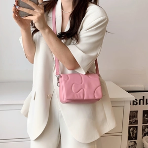 Pink quilted crossbody bag with puzzle stitching and long shoulder strap for women