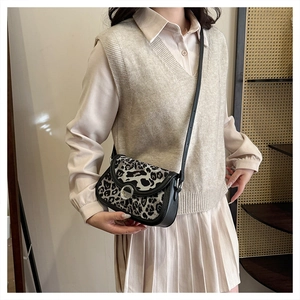 Detail of leopard print crossbody bag with silver magnetic buckle and leather strap