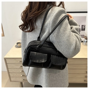 Detail of black crocodile texture shoulder bag with double pockets on grey wool coat