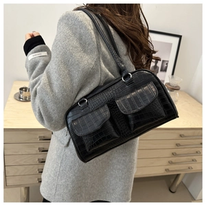 Detail of black faux crocodile leather shoulder bag with two front flap pockets