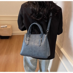 Détail du sac cabas rétro bleu brumeux avec doubles sangles porté à l'épaule