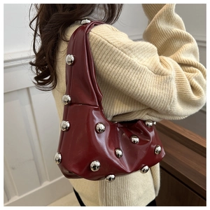Détail du sac baguette en similicuir bordeaux avec rivets décoratifs en métal argenté