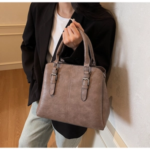 Détail du sac cabas vintage marron montrant les doubles poignées et boucles argentées