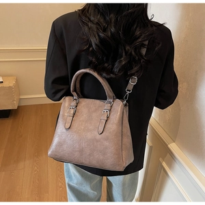 Vue détaillée d'un sac cabas en cuir marron vintage porté par un mannequin en intérieur