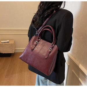 Détail du sac cabas en similicuir bordeaux avec boucles argentées et bandoulière amovible