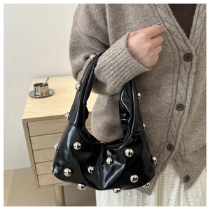 Détails du sac en cuir noir brillant avec clous sphériques argentés et plis