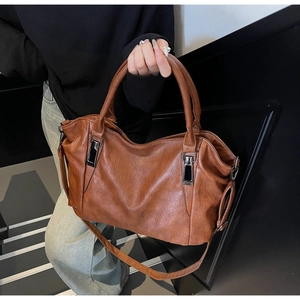 Détail du sac à main en cuir souple marron avec boucles en métal noir et bandoulière