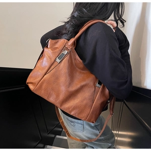 Détail du grand sac cabas en cuir souple marron caramel avec ferrures argentées sur modèle